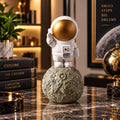 Statuetă Decorativă Astronaut pe Lună din Rășină – Design Premium Alb-Auriu, 6 × 6 × 12 cm