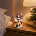 Glob de Zăpadă Premium de Crăciun cu Căsuță Iluminată, Moș Crăciun, Muzică, Lumină LED și Efect de Ninsoare – 15 × 10 cm